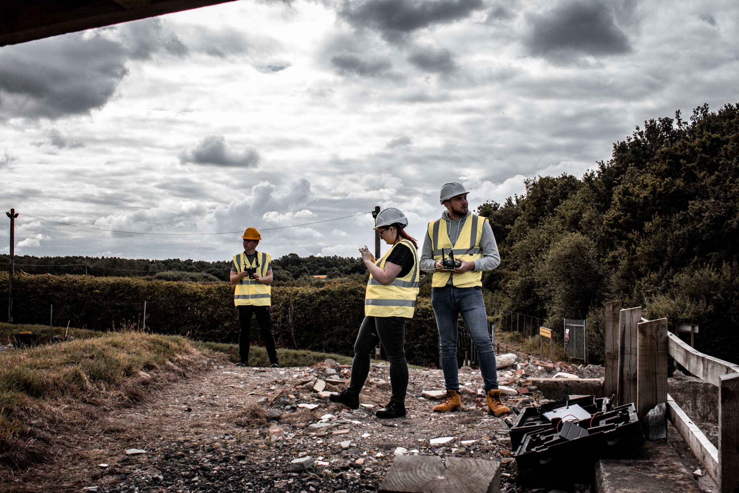 a group of people wearing safety vests and helmets flying a drone